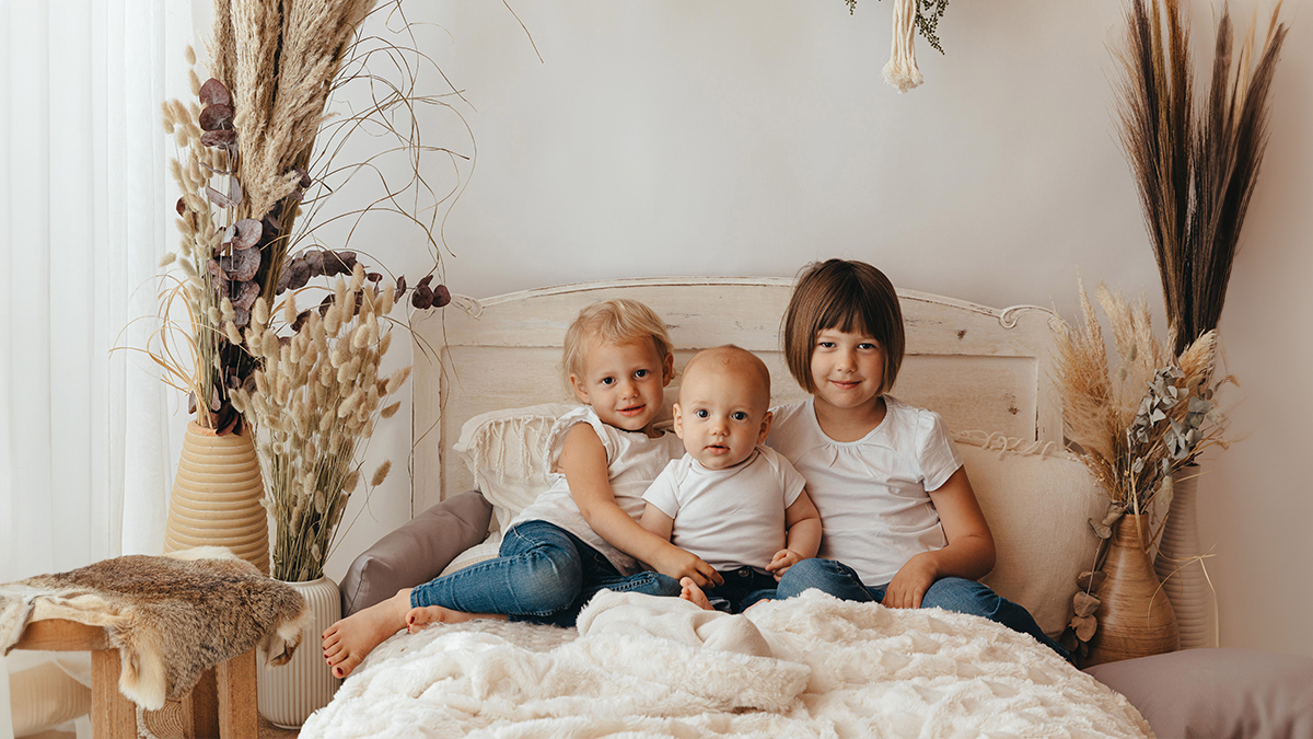 Geschwister auf einem Bett