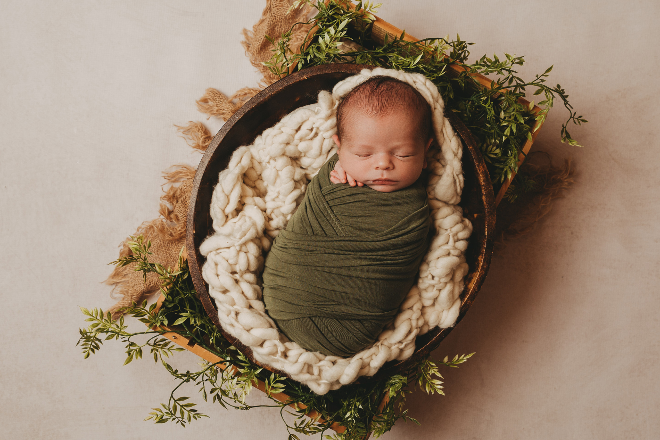 Ein Baby in einer Holzschale, bei einem Shooting